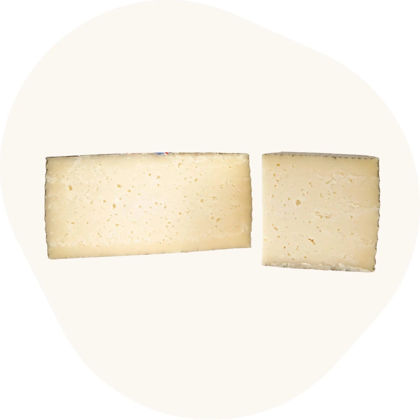 Aufgeschnittener gereifter Mischkäse Queso de Mezcla Curado von Baza, präsentiert in Viertel- und Halbstücken mit heller, feinlöchriger Käsetextur.