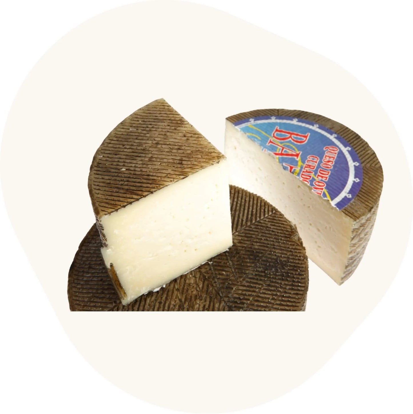 Aufgeschnittener gereifter Schafskäse von Baza, mit Stück in Viertel- oder Halbform und sichtbarer Rindenstruktur.