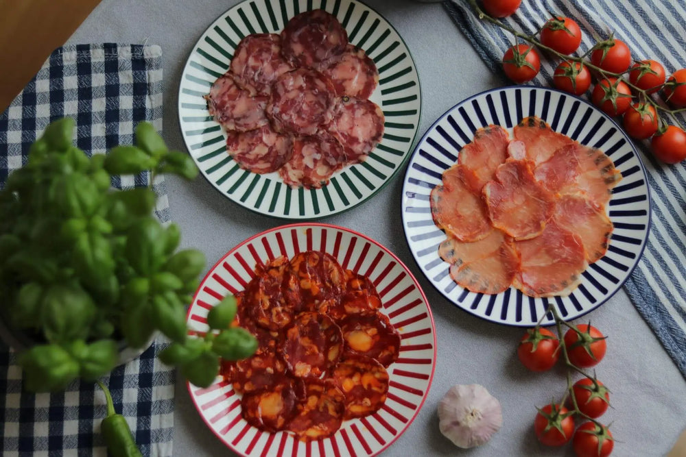 Spanisches Wurstset mit Chorizo, Salchichón und Lomo auf Tellern