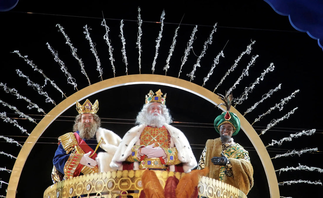 Drei Könige auf einer Parade beim spanischen Día de los Reyes Magos, festlich gekleidet auf einem geschmückten Wagen.