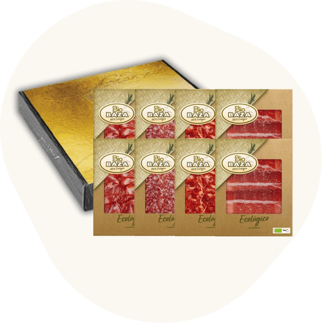 BioBAZA Set mit 8 ökologischen Ibérico-Aufschnittpackungen und Geschenkbox, auf rosa Hintergrund.
