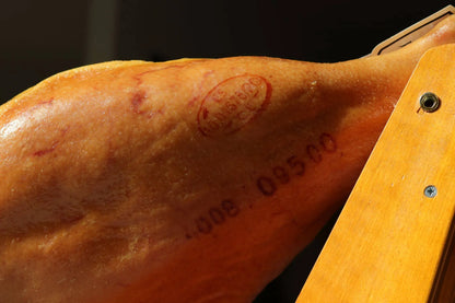 Detailaufnahme einer Schinkenkeule mit Qualitätsstempel und Chargennummer, typisch für spanischen Jamón