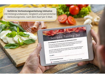 Tablet mit der digitalen Verkostungsanleitung des Serrano Tasting Sets, gehalten in den Händen, mit Serrano-Schinken und mediterranen Zutaten im Hintergrund