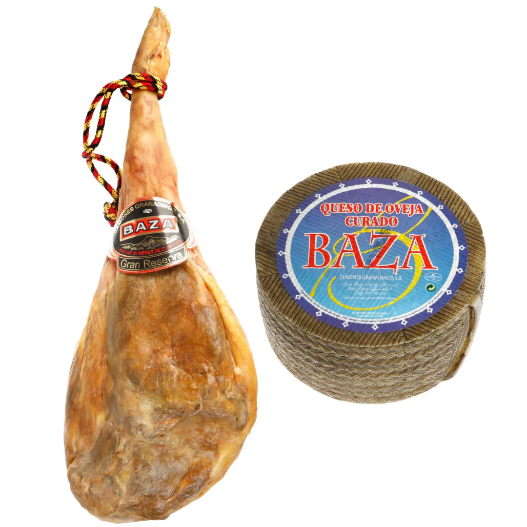 Ganze Hinterschinkenkeule Jamon Gran Reserva, 30 Monate gereift, zusammen mit einem ganzen Rad gereiftem Schafskase (Queso de Oveja Curado), 6 Monate gereift, freigestellt auf weissem Hintergrund.