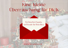 Geschenkkarte mit rotem Umschlag vor Weihnachtsbaum und Botschaft aus España.
