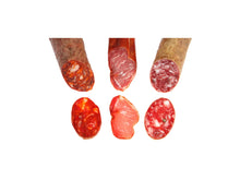 Set mit drei erstklassigen Ibérico-Spezialitäten (je 100 g) von Casa Ibera: Lomo (Lendenstück), Chorizo und Salchichón. Fein aufgeschnitten, vakuumverpackt und servierfertig, hergestellt aus Fleisch von iberischen Schweinen, freigestellt auf weißem Hintergrund.