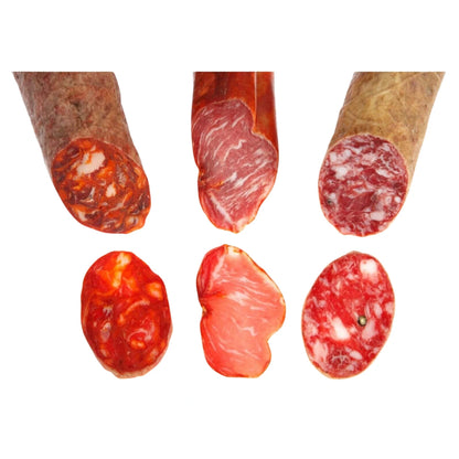 Anschnitt und Scheiben von Chorizo Ibérico, Lomo Ibérico und Salchichón Ibérico nebeneinander, mit sichtbarer Fettmarmorierung