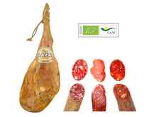 Ganze Hinterschinkenkeule Jamon Duroc aus 100% biologischer Erzeugung kombiniert mit einem Set aus verschiedenen iberischen Wurstspezialitäten (Chorizo, Salchichon, Lomo), Bio-Zertifikat sichtbar, freigestellt auf weissem Hintergrund.