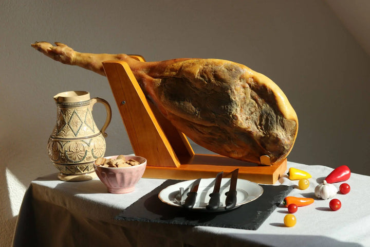 Spanischer Jamón Schinken im Halter mit Messer-Set auf dem Tisch
