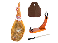 Ganze Hinterschinkenkeule Jamon Serrano Reserva von Jamones Baza, 14 Monate gereift, inklusive Schinkenhalter aus Holz, Schinkenmesser und Abdeckhaube, freigestellt auf weissem Hintergrund.
