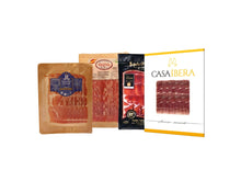 Probierset mit drei verschiedenen Jamon Sorten (Serrano und Iberico), geschnitten und vakuumverpackt (je 100 g), mit Reifegraden von 17 bis 36 Monaten von Jamones Juviles, freigestellt auf weissem Hintergrund.