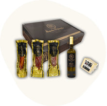 Majada Pedroche Degustationsbox mit ganzen Stücken Chorizo, Lomo und Salami Ibérico, dazu Weißwein und Käse – handwerkliche Feinkost aus Andalusien.