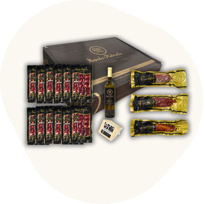 Majada Pedroche Degustationspaket mit zwölf Aufschnitt-Packungen, ganzen Wurststücken, Weißwein und Käse – exklusive Geschenkbox spanischer Delikatessen.