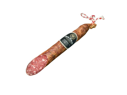 Ganze Stange Salchichón Ibérico de Bellota von Majada Pedroche, hergestellt aus Fleisch von iberischen Schweinen aus Eichelmast (Bellota), traditionell mit Pimentón und handwerklich gereift, vakuumverpackt für optimalen Frischeerhalt, freigestellt auf weißem Hintergrund.