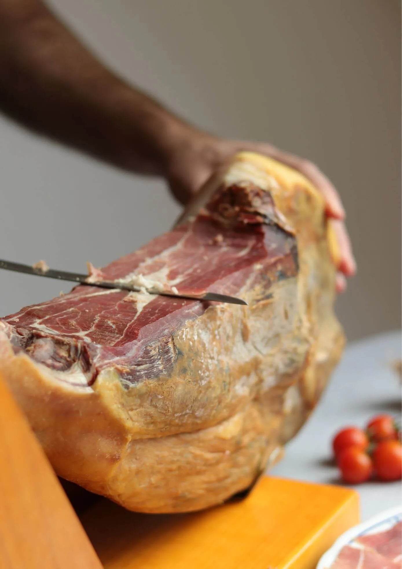 Angeschnittener Serrano Gran Reserva Jamón am Stück auf Schinkenständer, luftgetrockneter spanischer Schinken mit sichtbarer Marmorierung