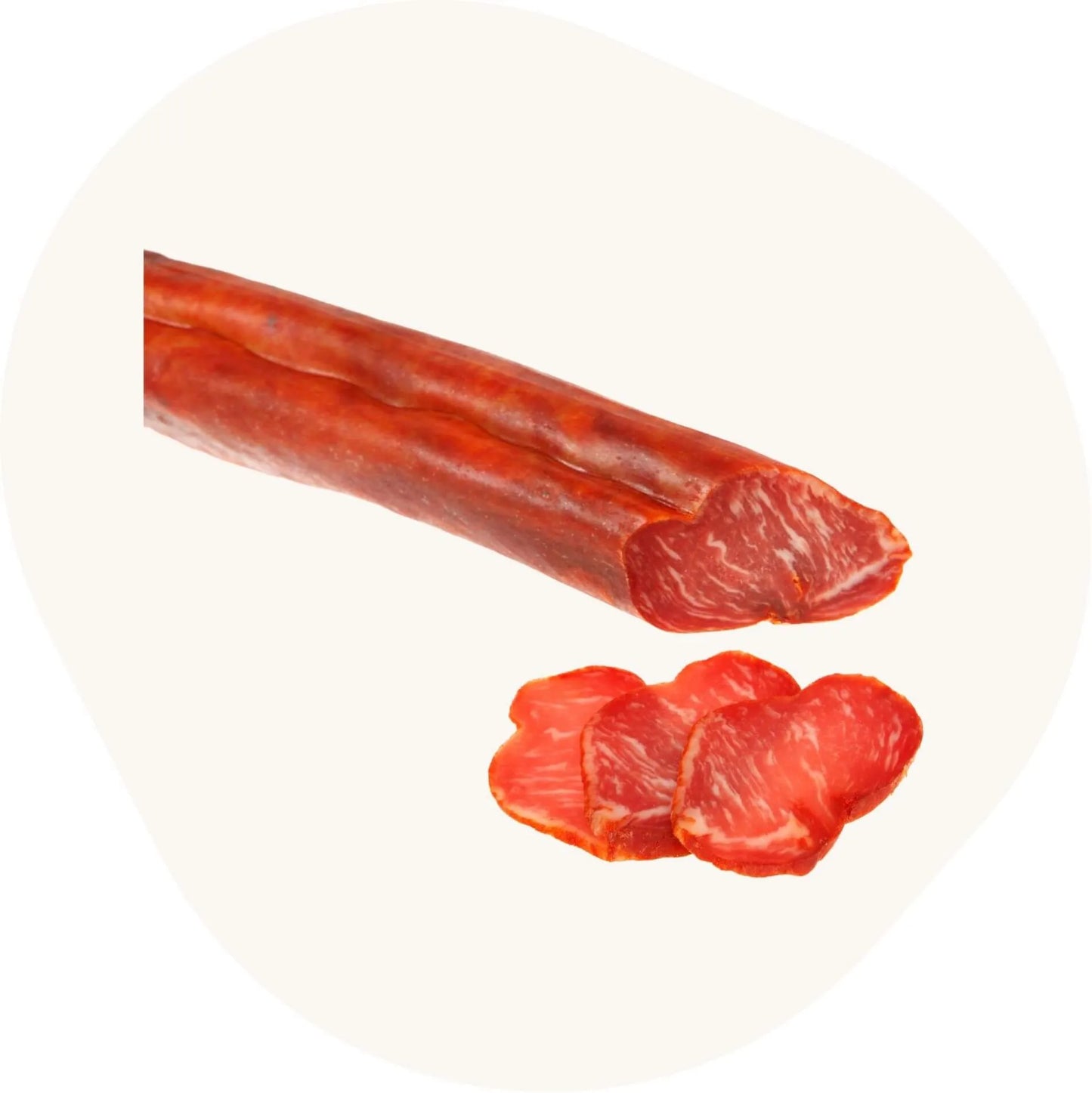Spanische Schweinelende (Lomo), luftgetrocknet, angeschnitten mit mehreren dünnen Scheiben in kräftigem Rot und feiner Marmorierung.