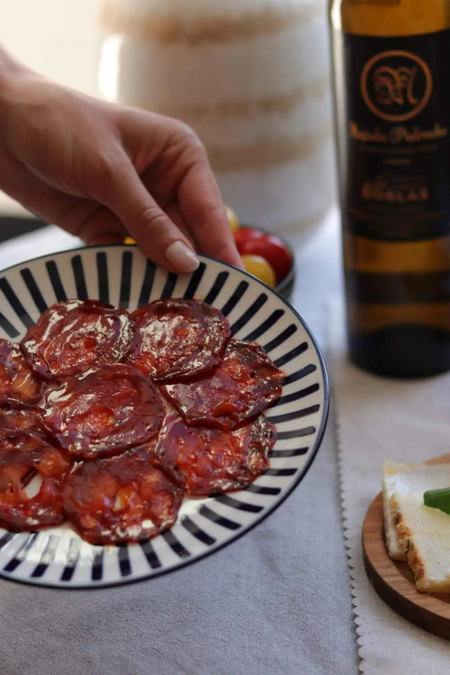 Spanischer Chorizo in Scheiben auf Teller, serviert mit Wein