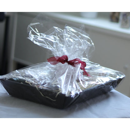 Feinkost-Set von La Tradición in einem Korb als Geschenk verpackt, mit transparenter Folie und Schleife in Bordeauxrot