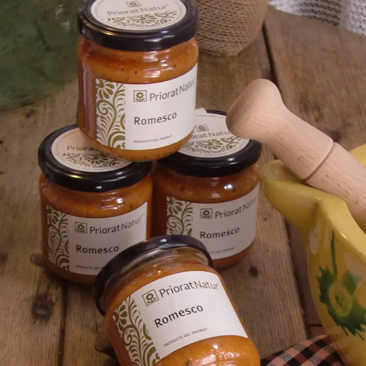 Vier Gläser Romesco-Sauce von Priorat Natur auf Holzuntergrund, traditionelles Familienrezept aus dem Priorat, Katalonien, mit Holzmörser im Hintergrund